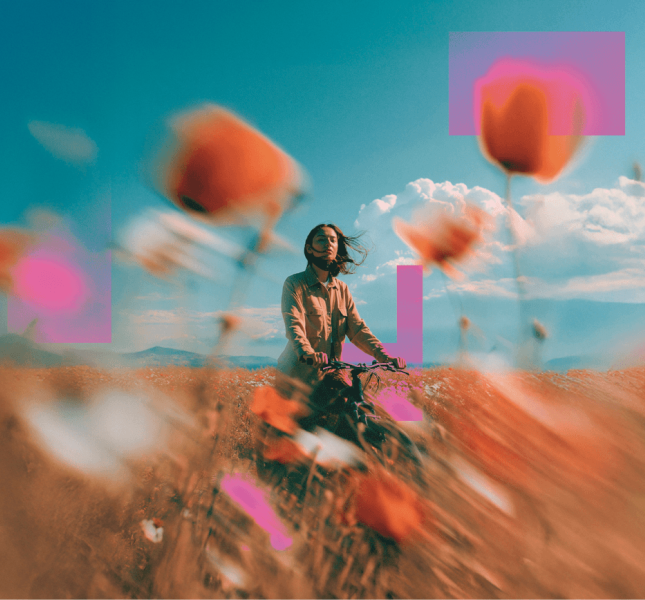 Girl standing in a flower field with a bicycle 