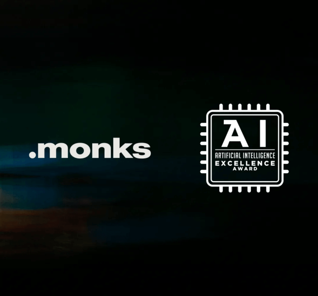 The Monks logo displayed next to a white microchip emblem that reads "AI ARTIFICIAL INTELLIGENCE EXCELLENCE AWARD," set against a dark, abstract background featuring colorful, blurred motion light trails and a solid purple geometric shape on the left.
