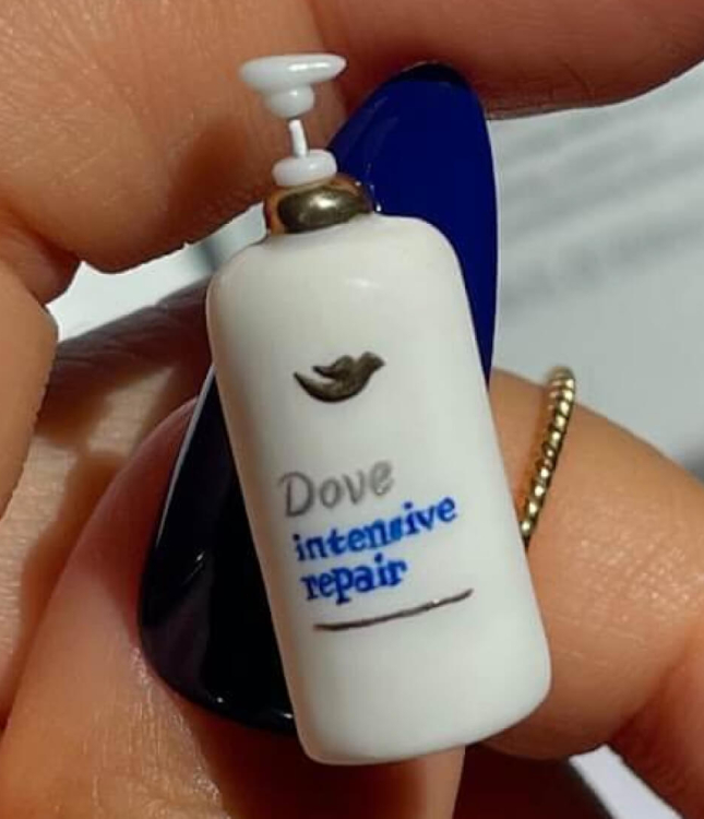 A hand-made miniature Dove Hair product affixed to the blue thumbnail of an influencer.
