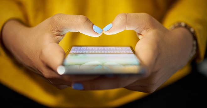 Hands typing on a cellphone