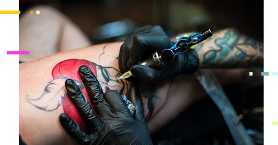 A tattoo artist giving a person a tattoo on their arm