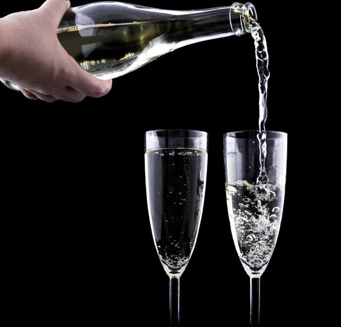 A champagne bottle pouring into glasses