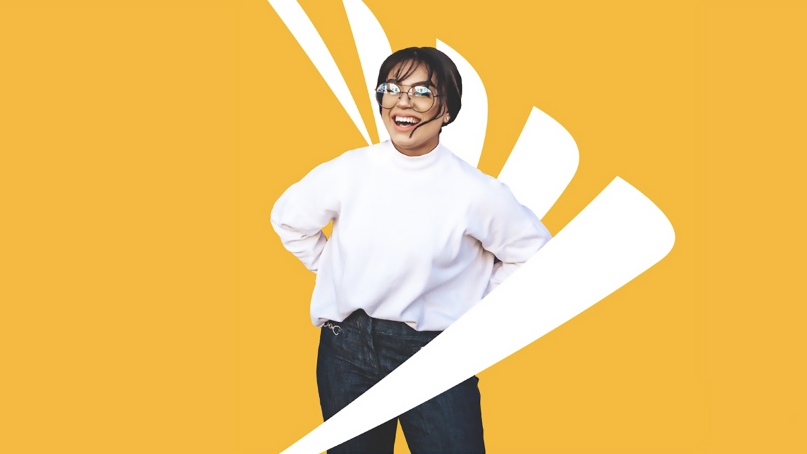 A person smiling and standing in front of a Sprint logo