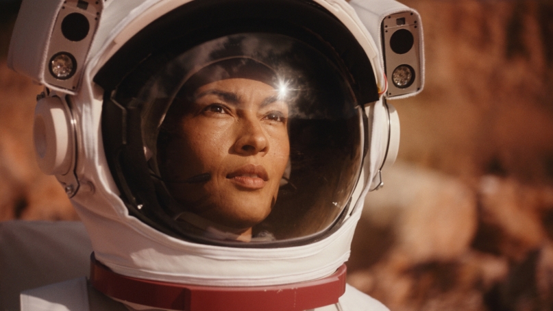 portrait of a woman in a space suit against a red rock background