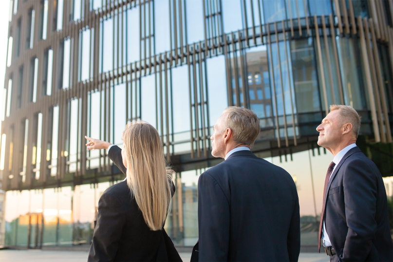 Three people looking at an office building