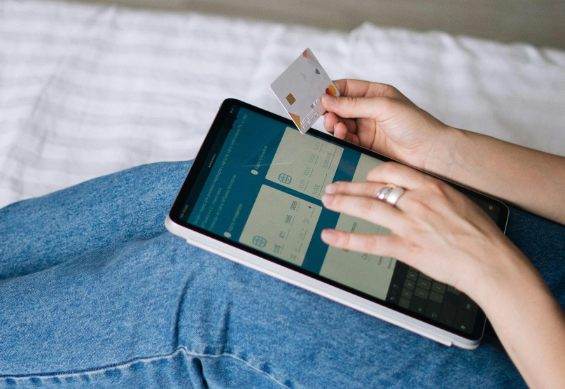 A person on a tablet making a purchase using a credit card