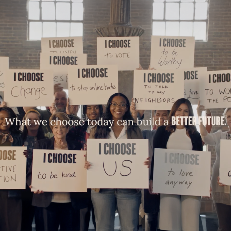 A group of people holding signs fostering unity and hope during the divisive US elections.