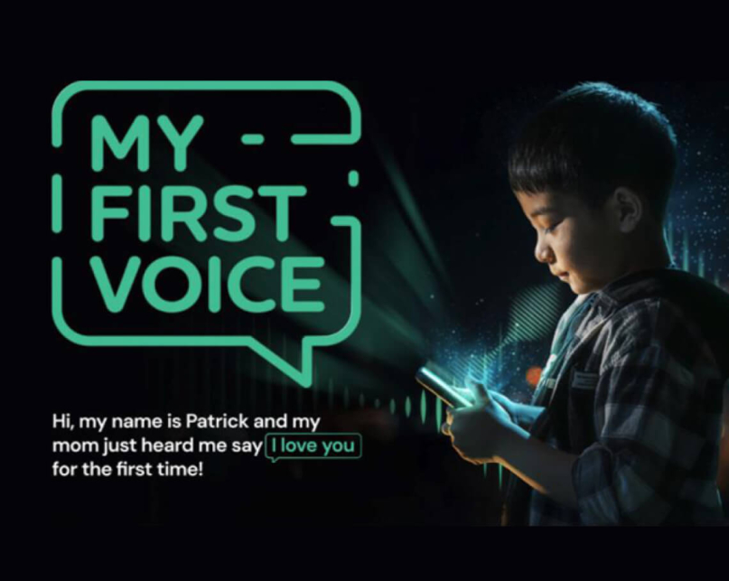 A small boy looking at a glowing phone with text that reads "Hi, my name is Patrick and my mom just heard me say 'I love you' for the first time!".