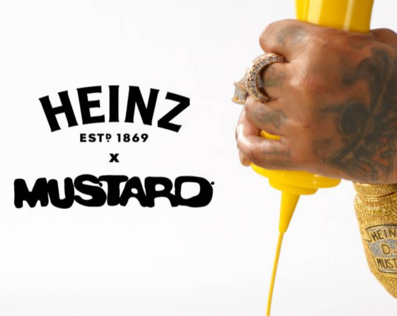 DJ Mustard's hands squeezing a bottle of Heinz yellow mustard.