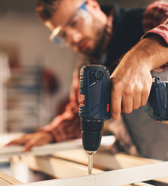 man drilling wood