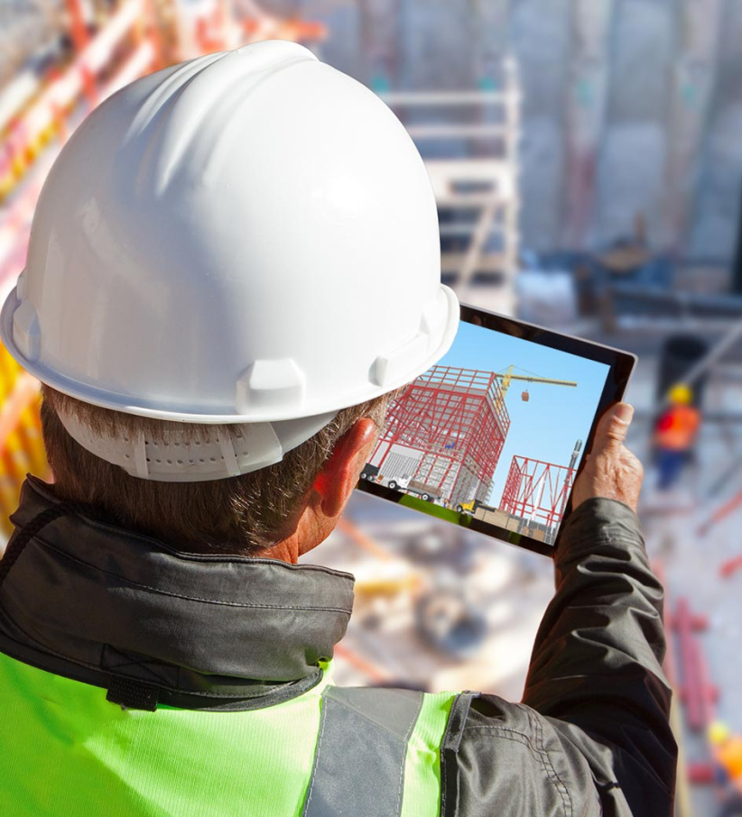 A construction worker looking at a tablet