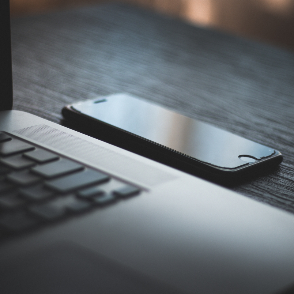 Image of a laptop and a closed phone next to it