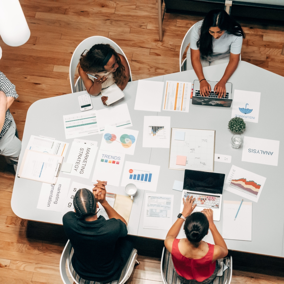Employees sitting at a table consulting. Seen from above.