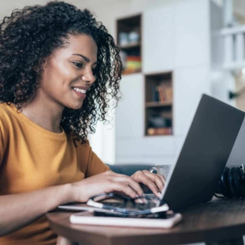Girl in yellow shirt typing at computer