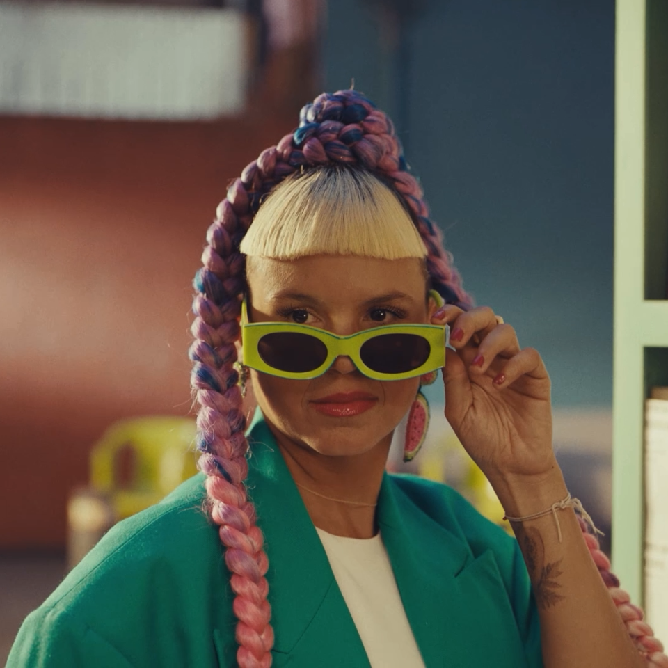 A woman pulling her sunglasses below her eyes to peer over them