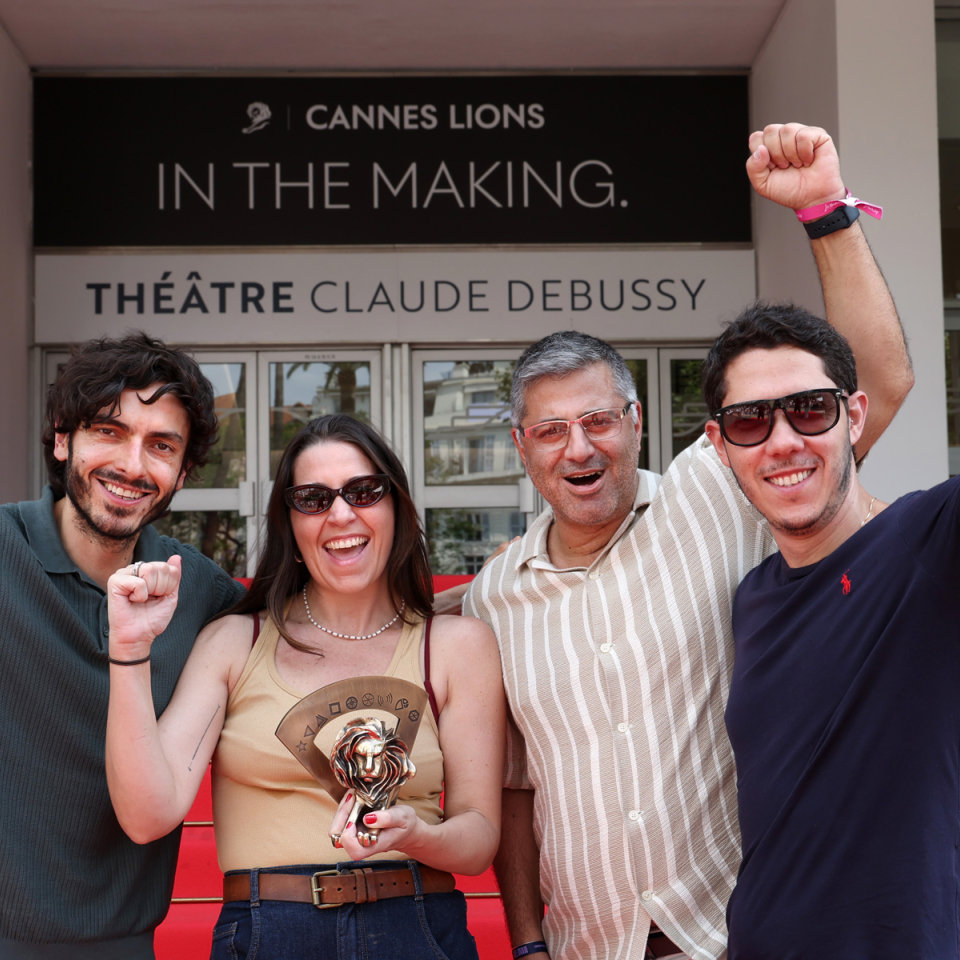 Monks employees holding a bronze Cannes Lion trophy on the red carpet