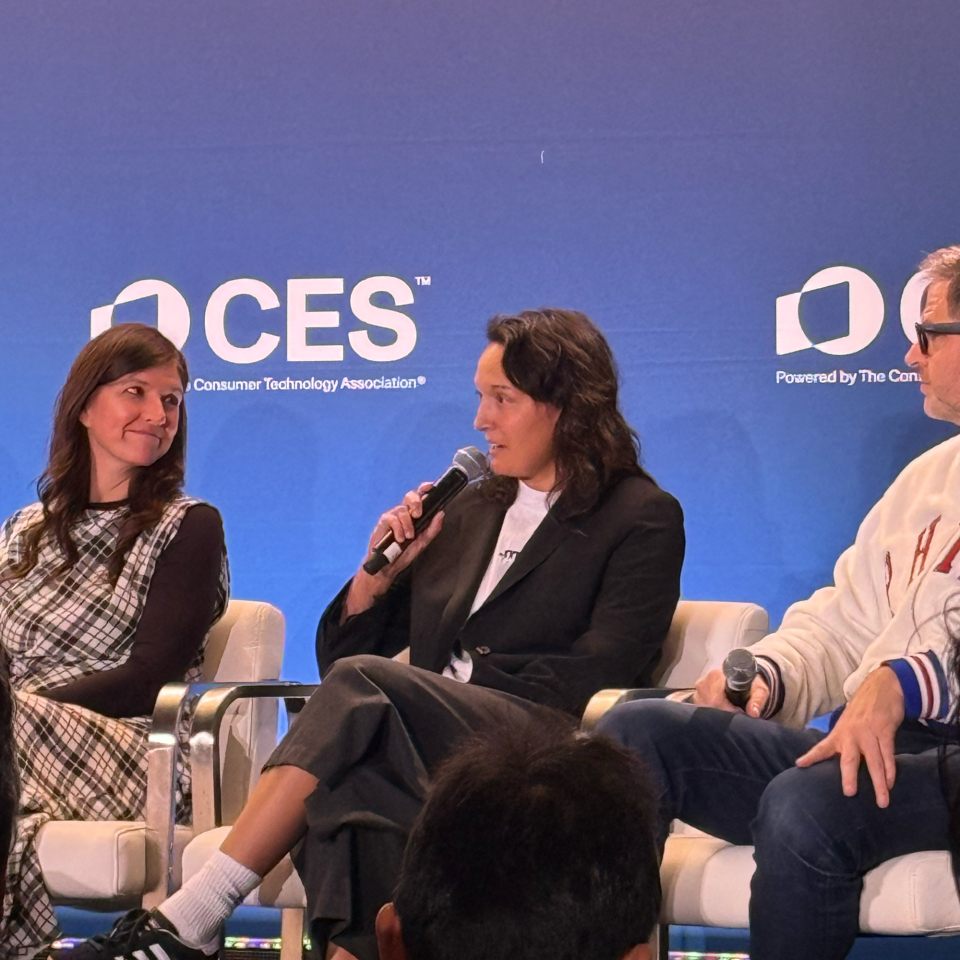 woman on panel on a stage between two people