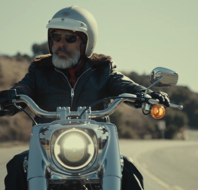A person rides a motorcycle down the road