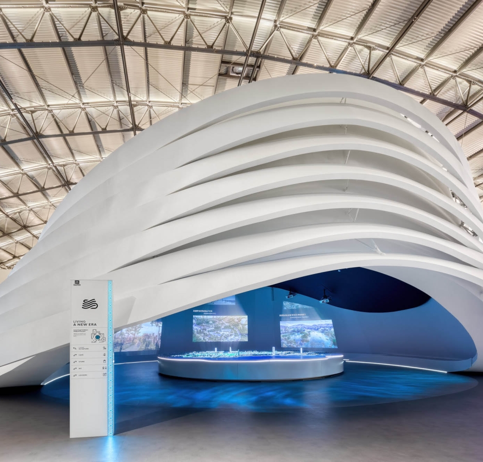 A large white circular exhibit piece with large screens on the inside of it