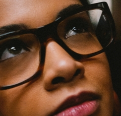 Closeup of a women wearing Ray-Ban glasses with a dark heavy frame.