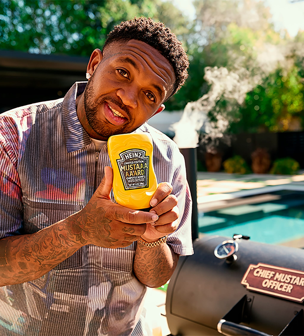 DJ Mustard smoking food on a large smoker using Heinz mustard