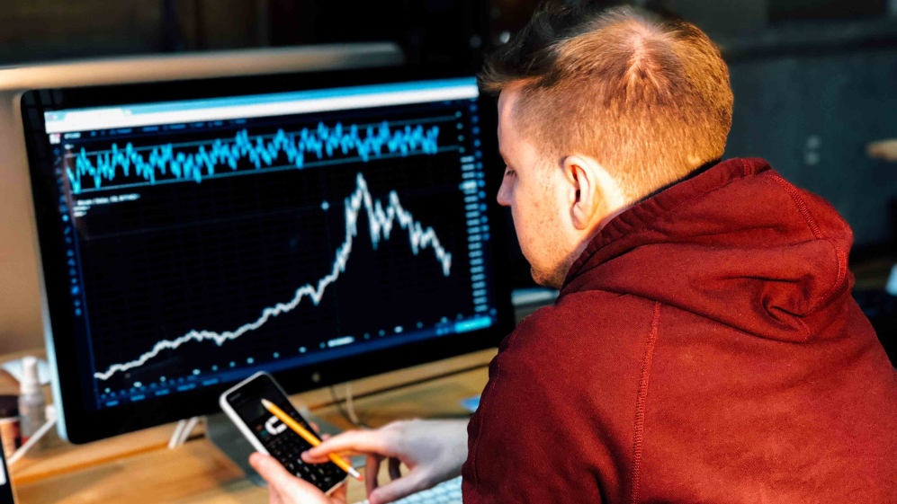 A person staring at an analytics dashboard on a computer and phone