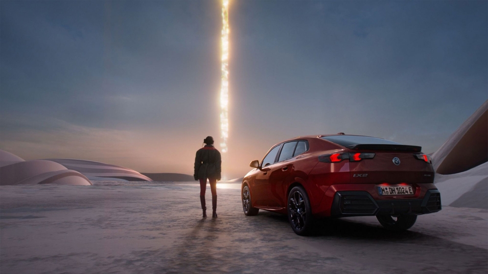 Lil Miquela stands next to the new BMW X2 and stares at a futuristic beam of light that shines from the sky to the ground.