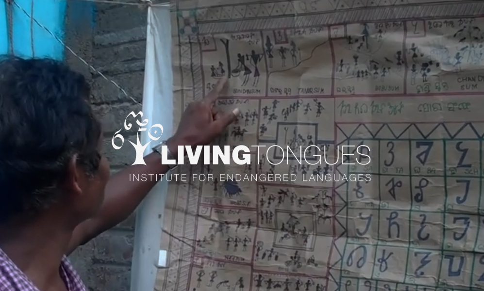 A large paper pasted on the wall with a foreign language on it. The logo of 'living Tongues' in white letters is added on top of it.