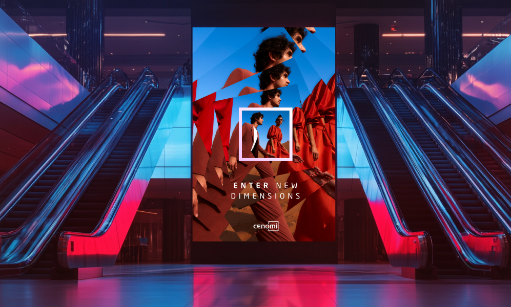 A photo of a digital display ad for Cenomi, featuring a couple in a desert with the copy "Enter new dimensions." Escalators flank both sides of the display, which appears to be in a mall.