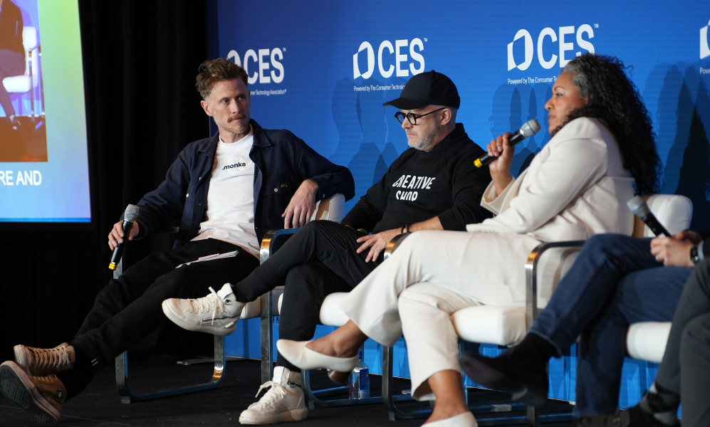 three people sitting on a stage at CES