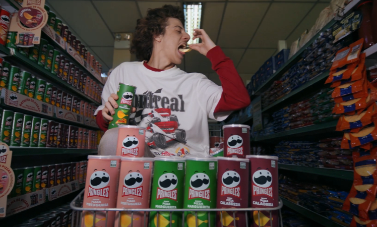 white man with long hair eating pringles snacks