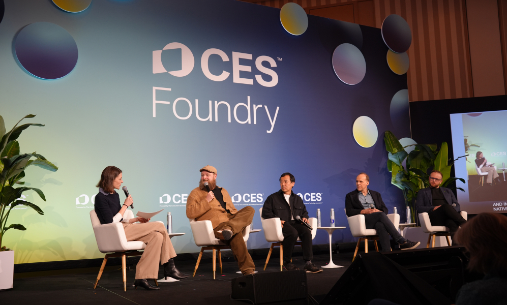 a panel of people on a stage with a sign that reads "CES"