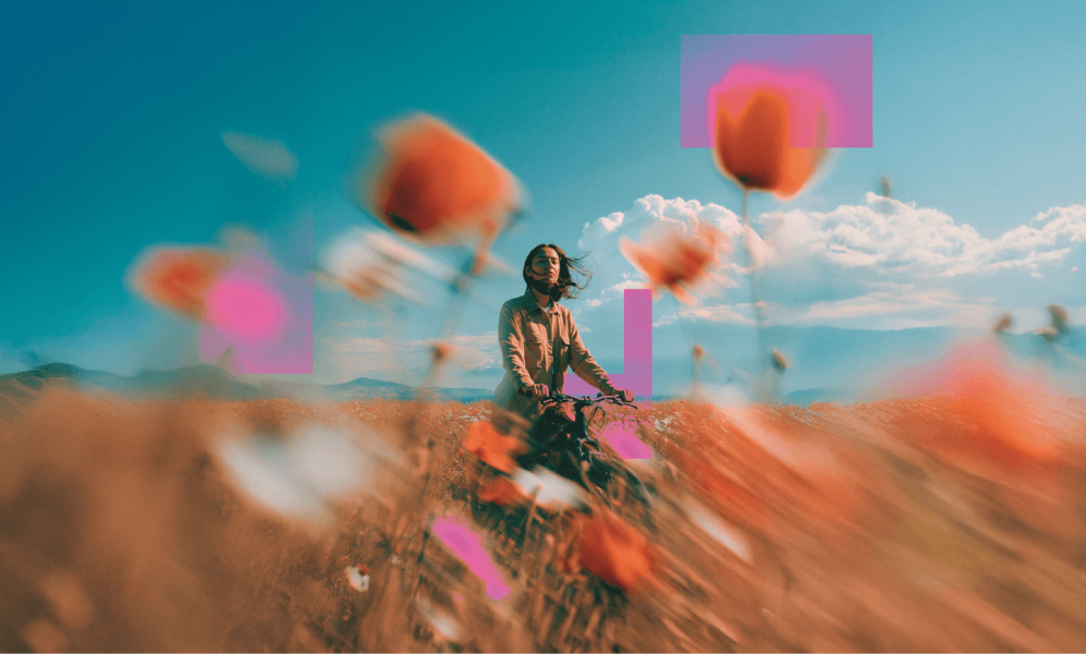 Girl standing in a flower field with a bicycle 