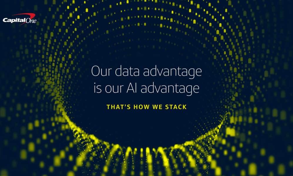 A digital graphic with a dark blue background featuring a swirling, three-dimensional tunnel made of small, glowing yellow dots. The Capital One logo is in the top left corner. Centered on the screen is white text that reads, "Our data advantage is our AI advantage," followed by smaller yellow text underneath saying, "THAT'S HOW WE STACK."