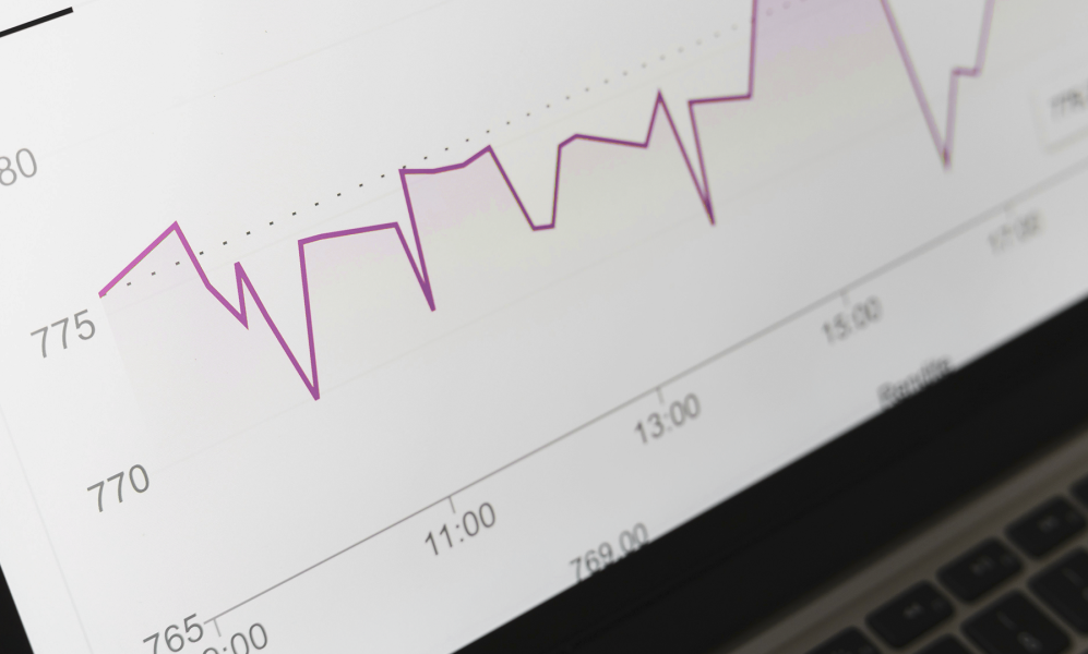 Monitor de laptop com gráfico de métricas e resultados de negócios.