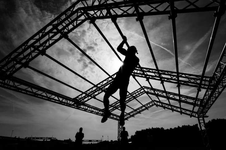 A person doing crossfit climbing a rope