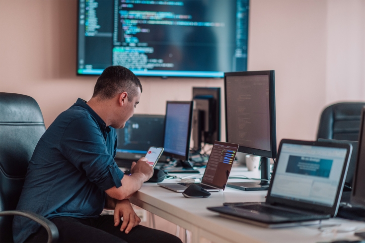 A person working at a desk with a bunch of computer equipment