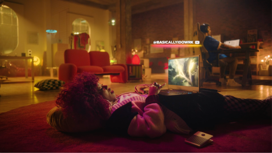 A person laying on the ground using an HP Omen laptop