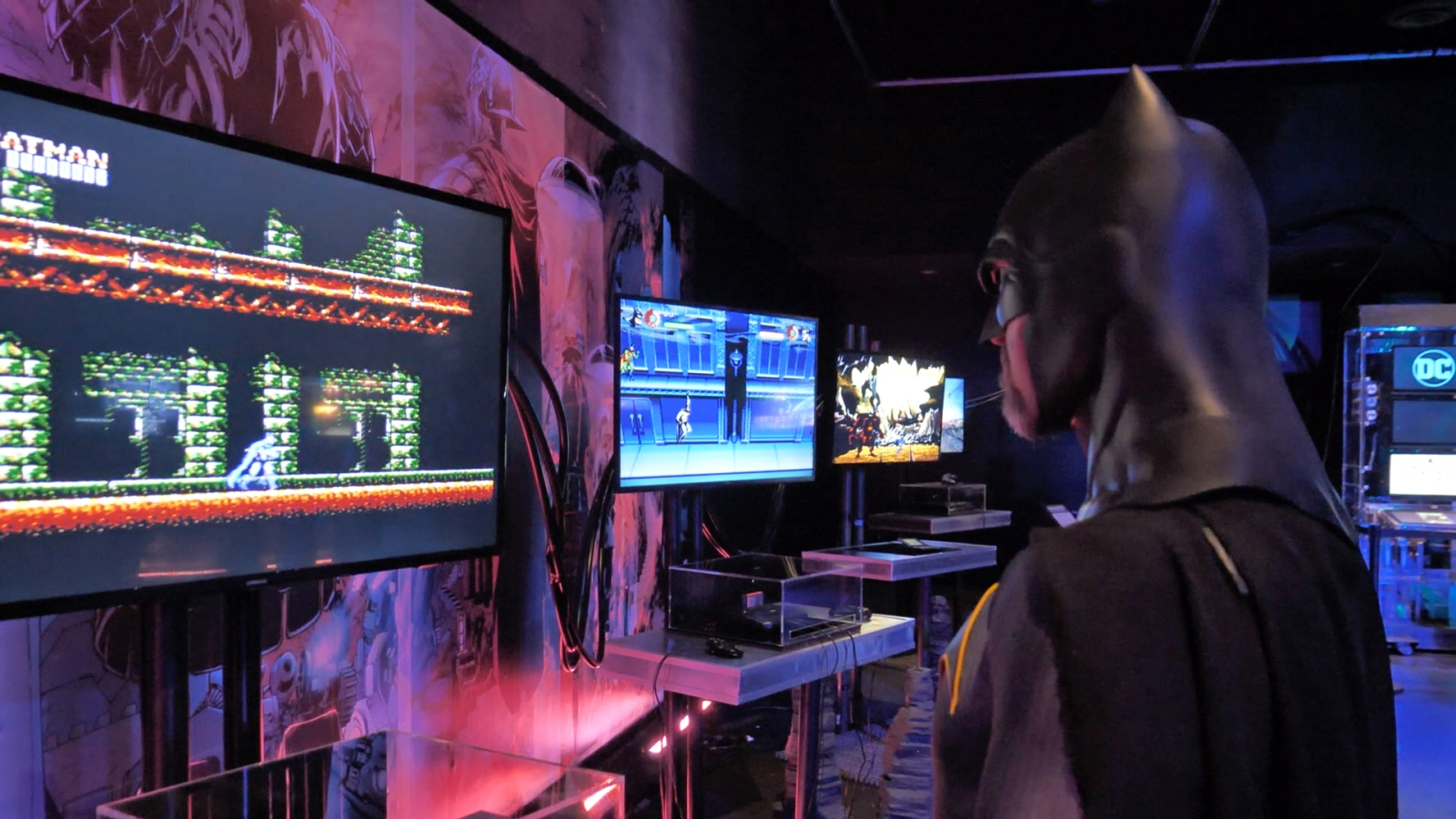 Man dressed as Batman playing old Batman video game in the Batman Experience