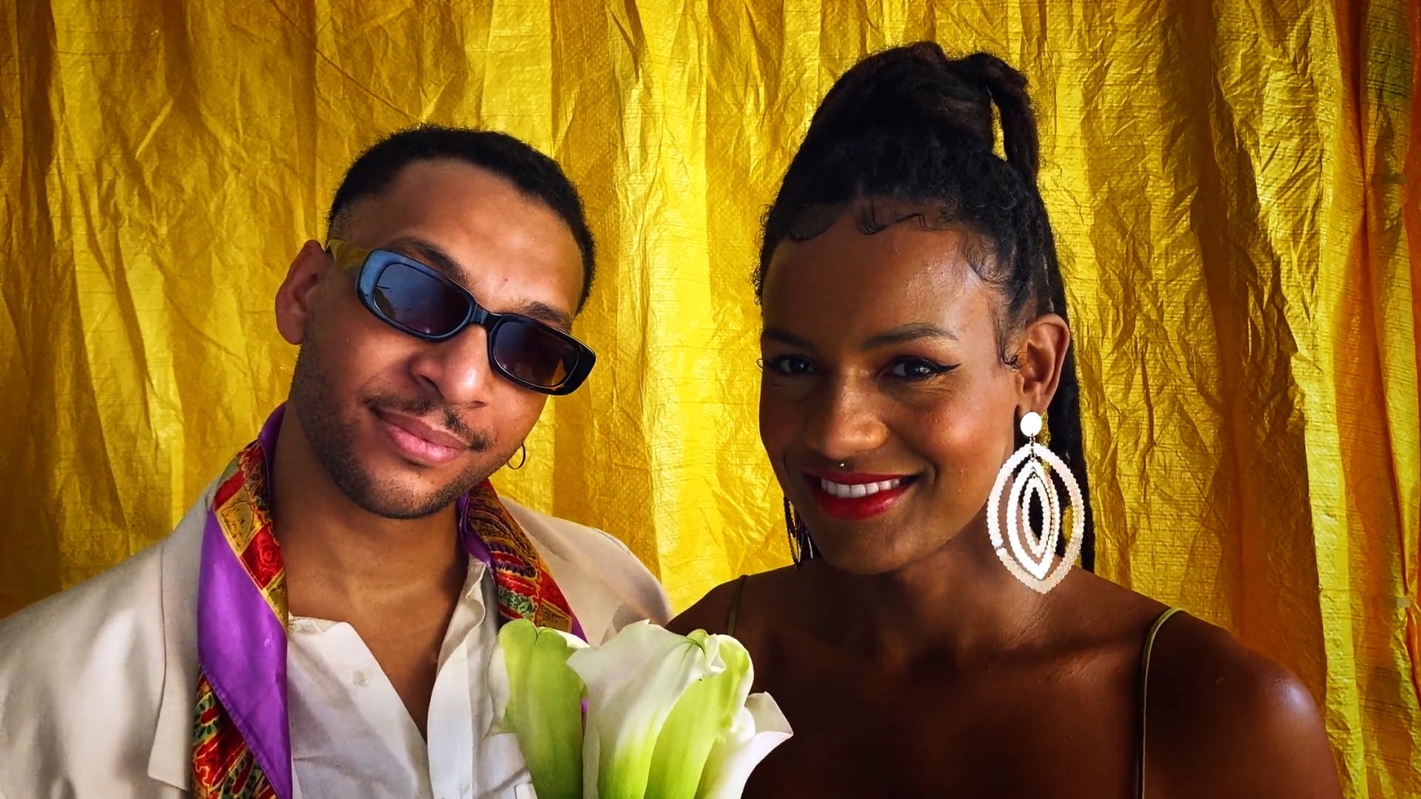 Couple smiling and holding flowers