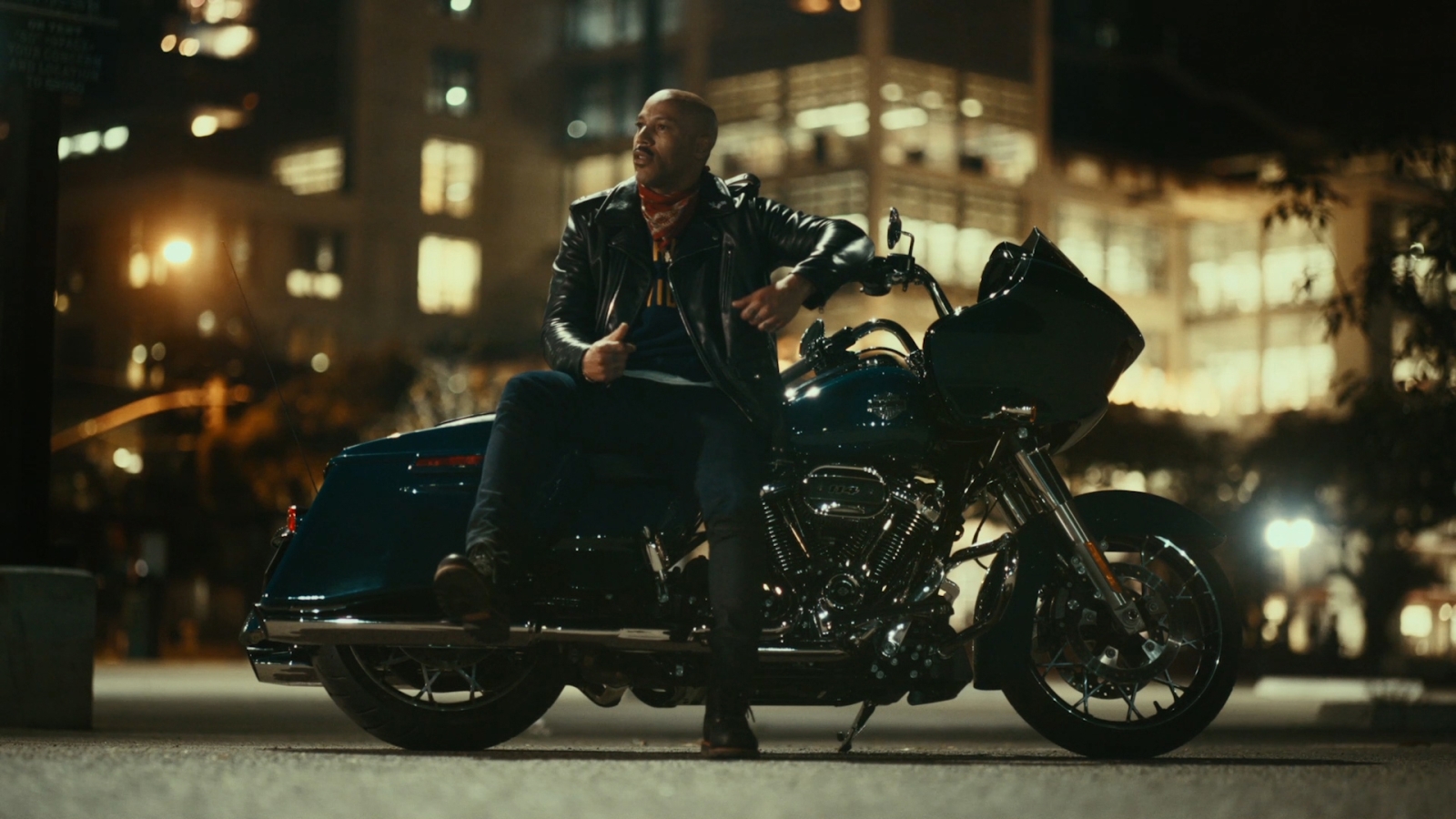 A person stands in front of a Harley Davidson motorcycle