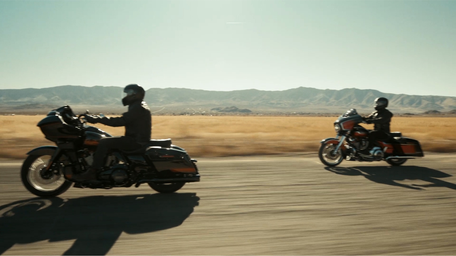 Two people riding Harley Davidson motorcycles