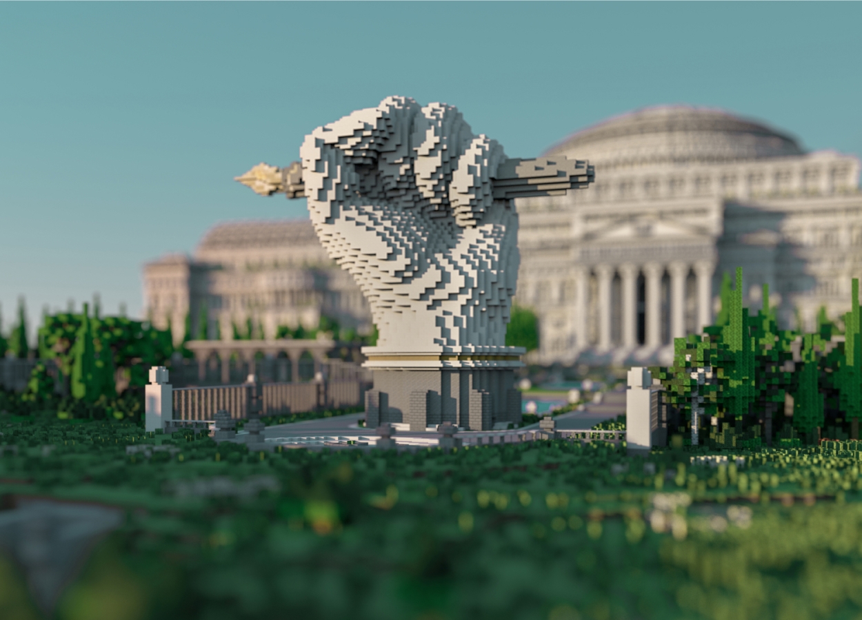 A statue of a hand holding a pen outside of the library