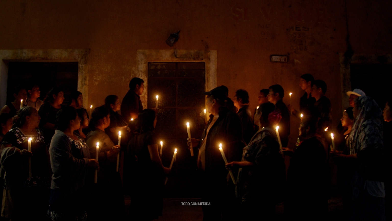 A group of people hold candles together