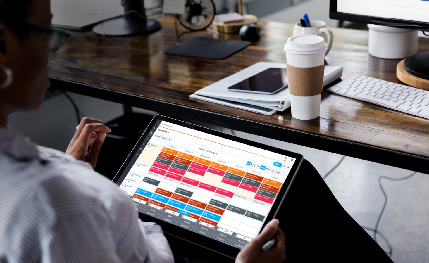A person sitting at their desk using paycor on a tablet