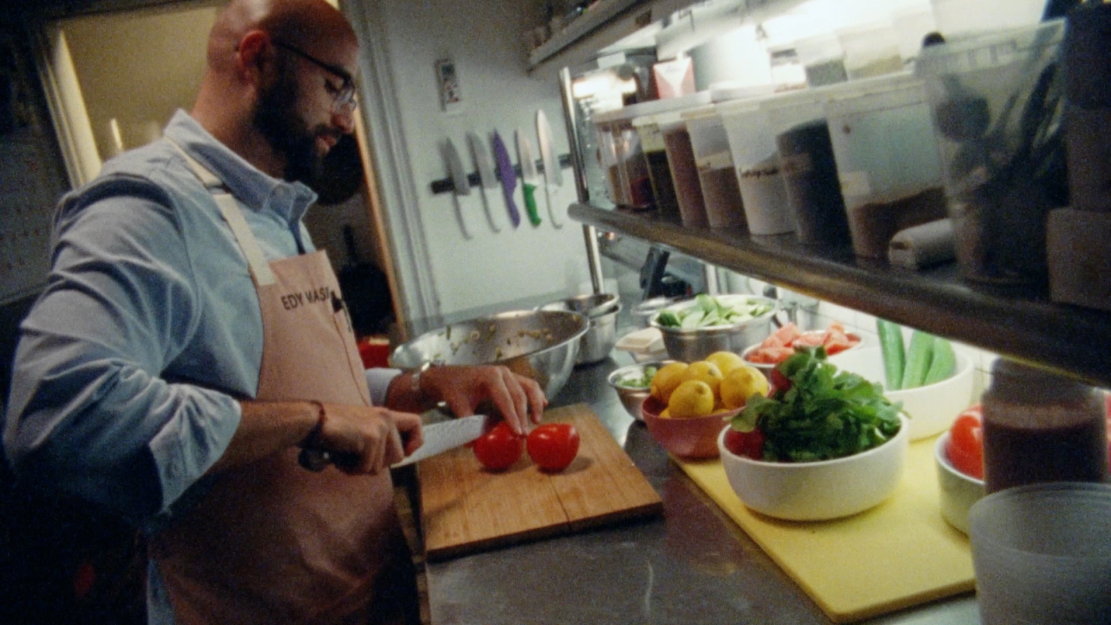 A chef cuts vegetables in a restaurant kitchen