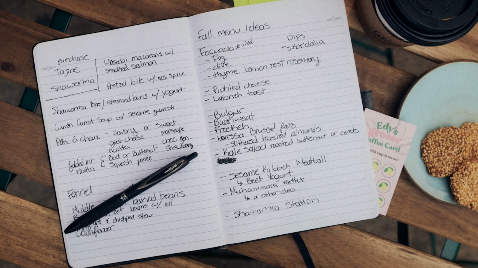 A notebook filled with notes sitting on a table with a uni pen