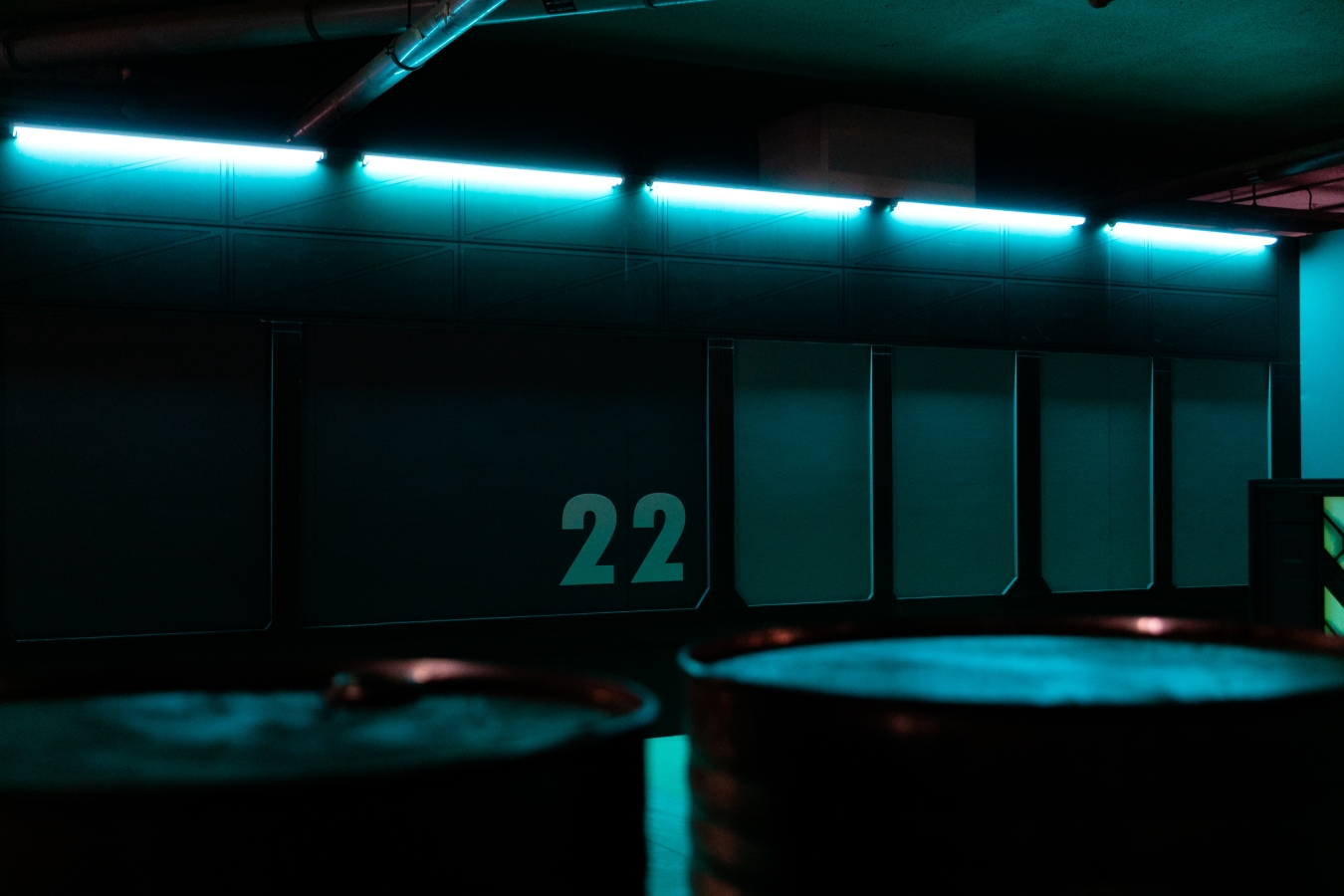 A dark exhibit lit in blue and the number 22 on a wall