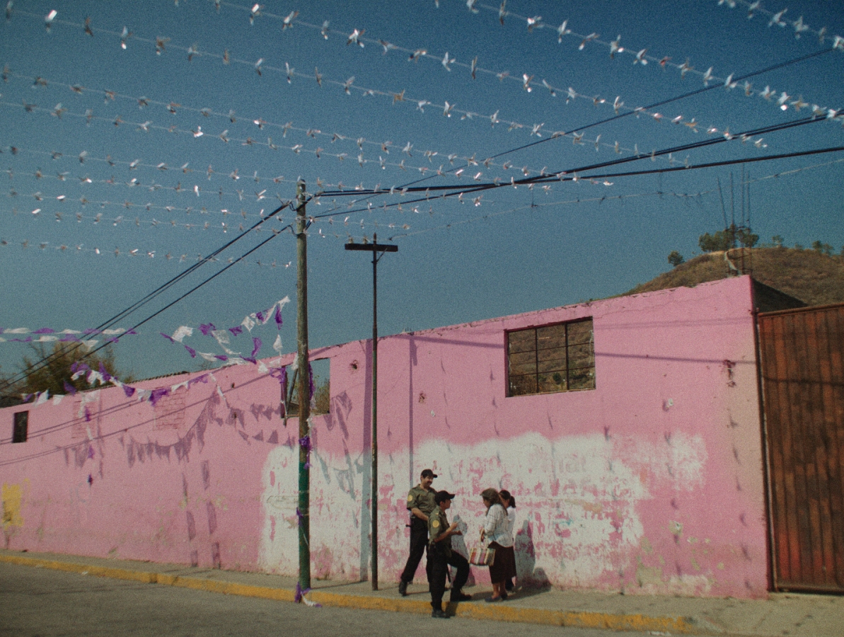 police asking somebody on the street in front of a pink wall about the missing girl.