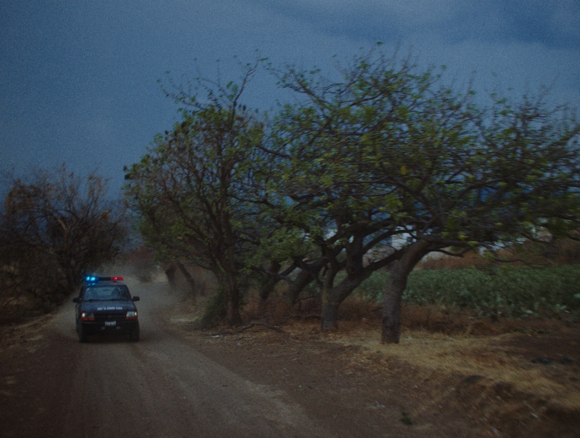 Police car is racing on a dirt road to a lead where the girl might be.